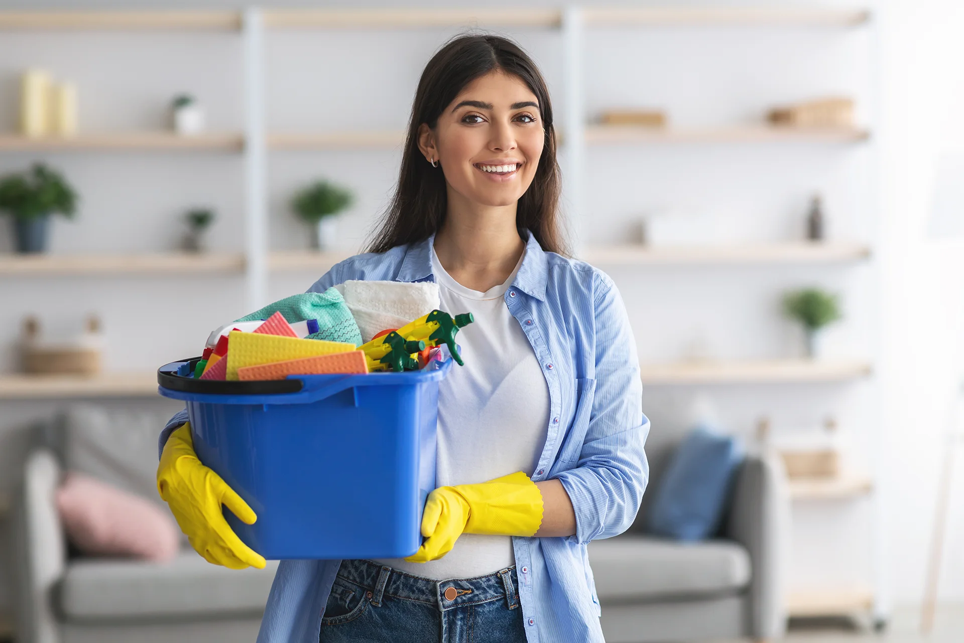Professional house cleaner holding bucket supplies